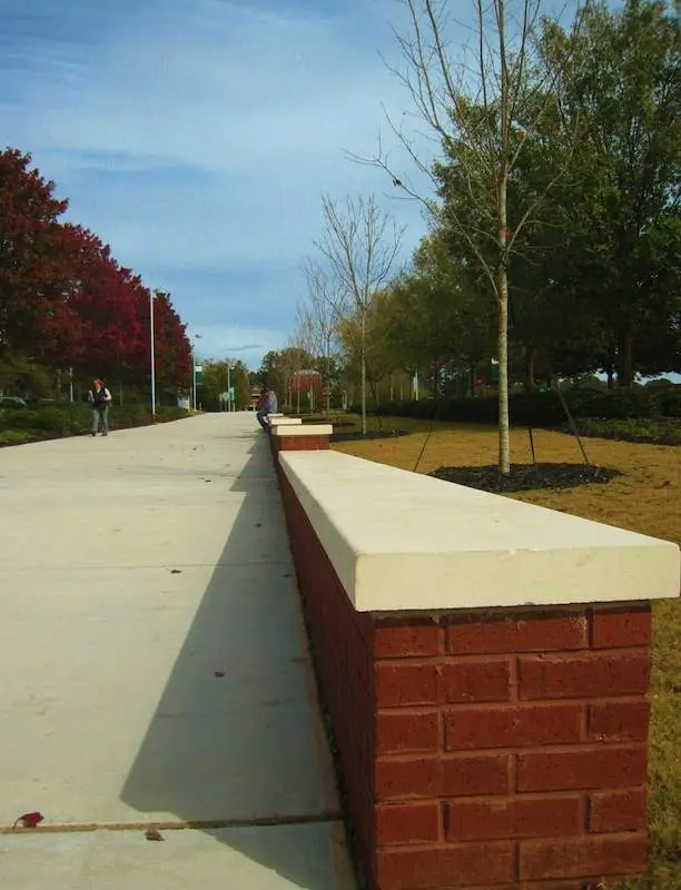 A brick wall on the side of a road.