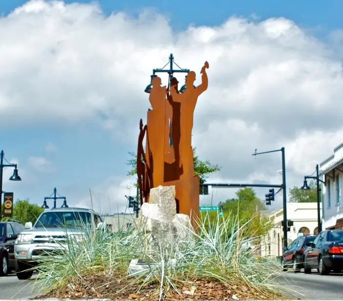 A sculpture of people standing on top of a hill.