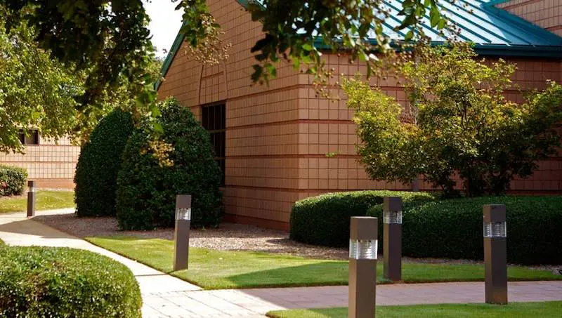 A building with trees and bushes in the background.