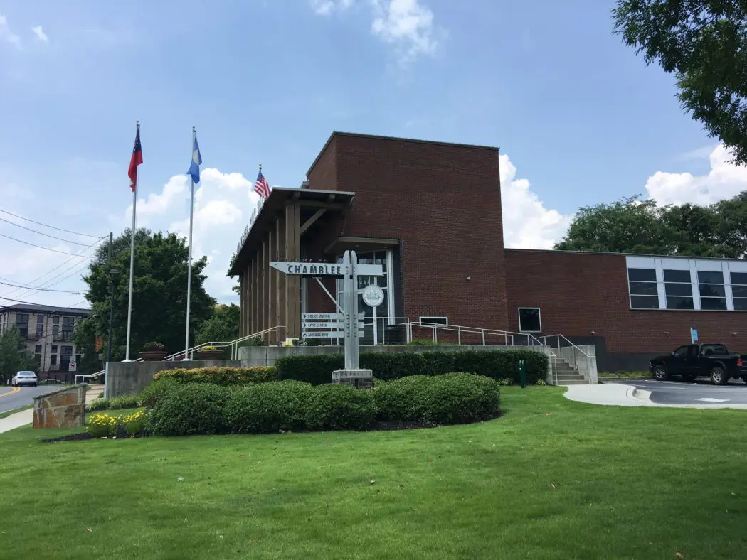 A building with flags in the background and grass around it.