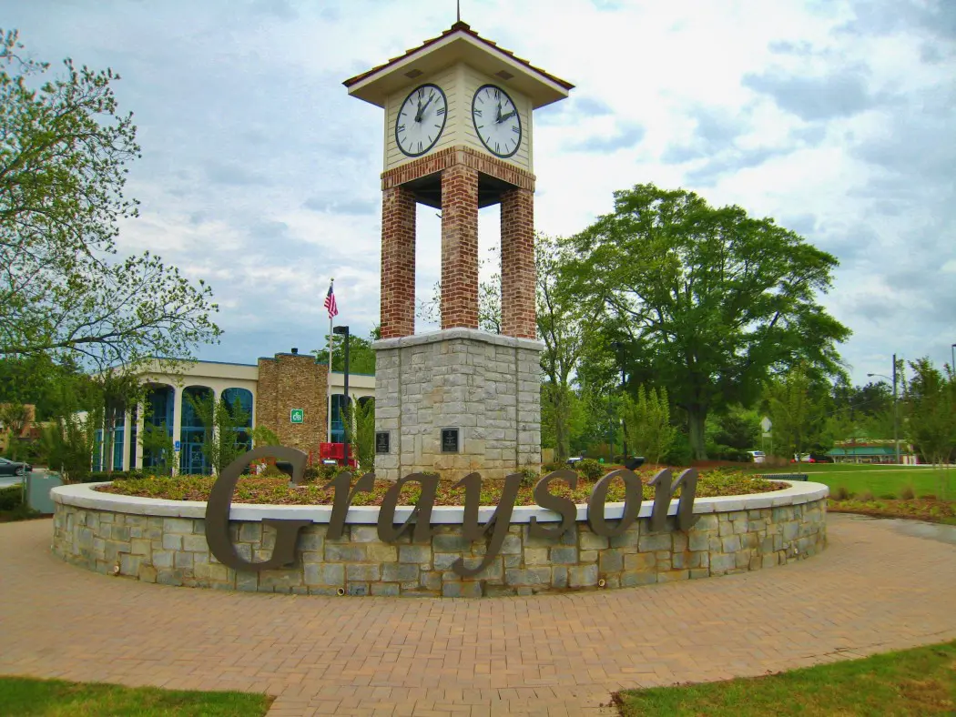 A clock tower with the word " gainesville " written in front of it.