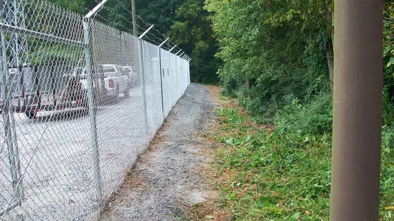 A fence that is on the side of a road.