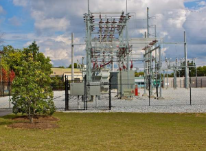 A power plant with many wires and trees